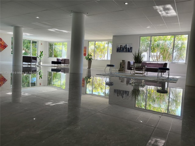 interior space with decorative columns and a drop ceiling