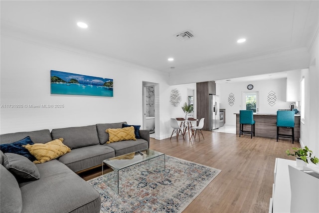 living room featuring ornamental molding and light hardwood / wood-style flooring