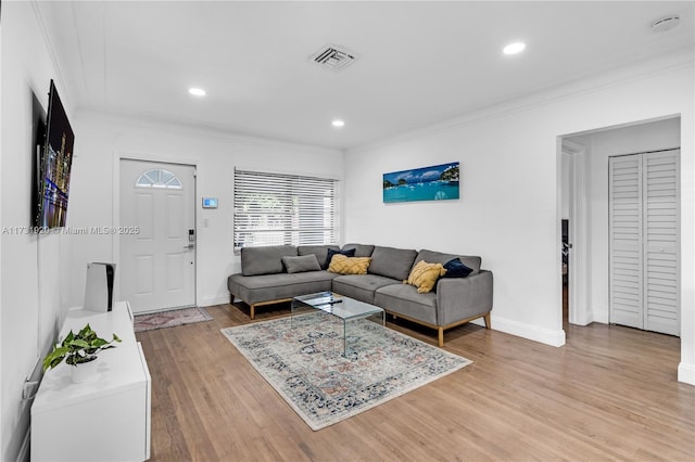 living room featuring crown molding and light wood-type flooring