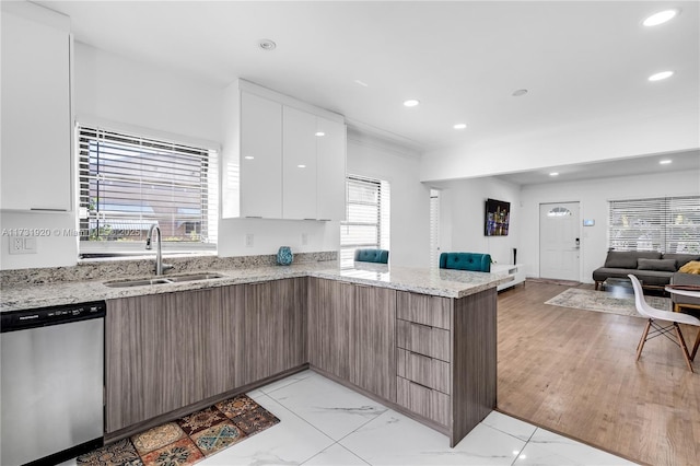 kitchen featuring stainless steel dishwasher, a wealth of natural light, sink, and white cabinets