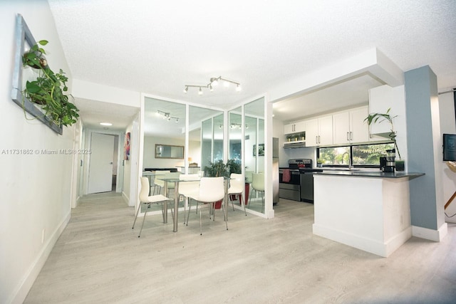 kitchen with white cabinetry, sink, light wood-type flooring, electric range, and a textured ceiling