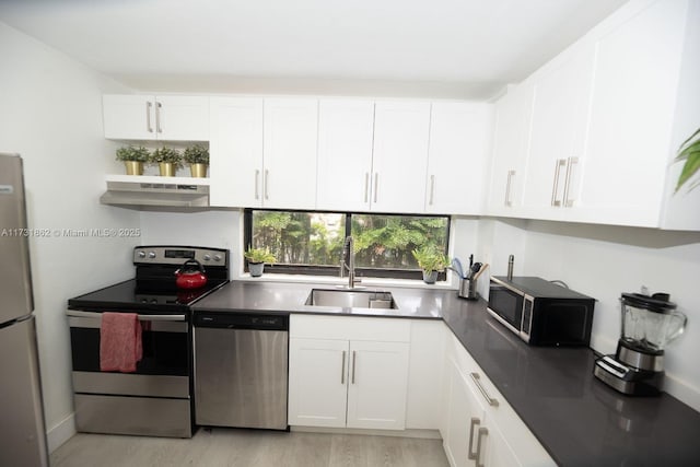 kitchen featuring appliances with stainless steel finishes, sink, light hardwood / wood-style flooring, and white cabinets