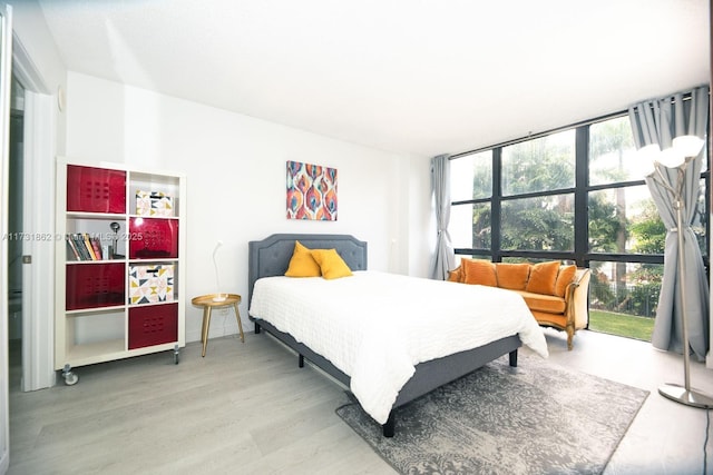 bedroom featuring wood-type flooring and expansive windows