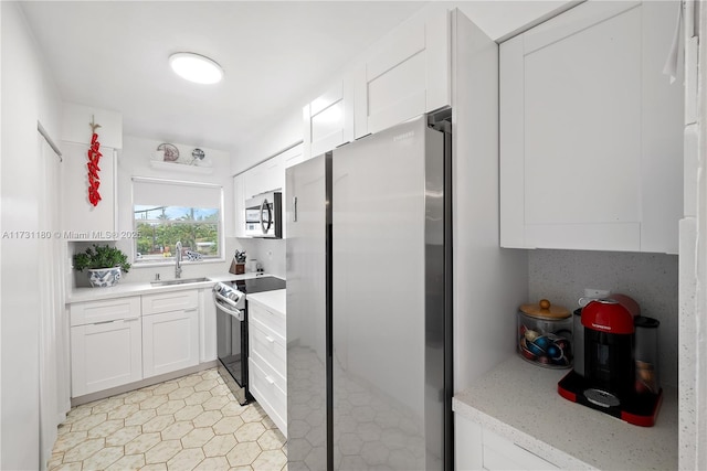 kitchen featuring stainless steel appliances, sink, decorative backsplash, and white cabinets