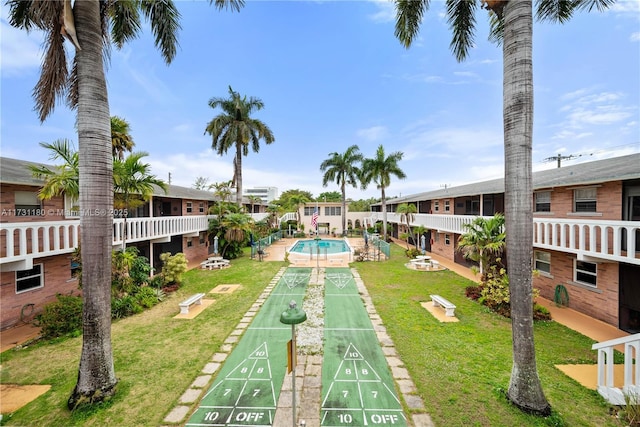 view of community featuring a pool and a yard