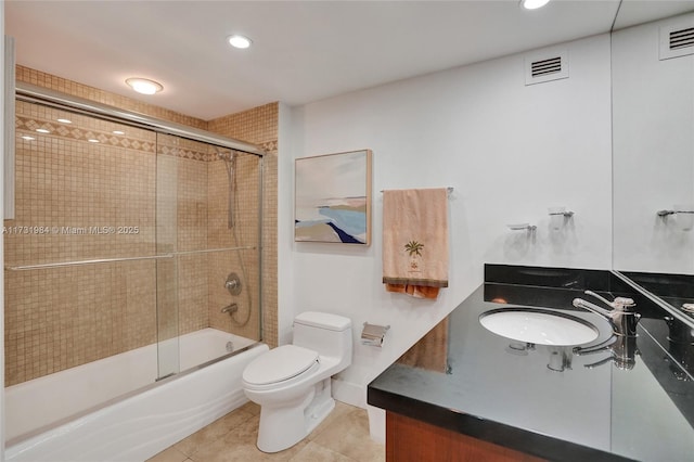 full bathroom with bath / shower combo with glass door, sink, tile patterned floors, and toilet