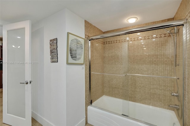 bathroom with bath / shower combo with glass door