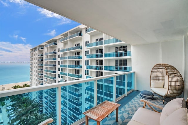 balcony featuring a water view and a view of the beach