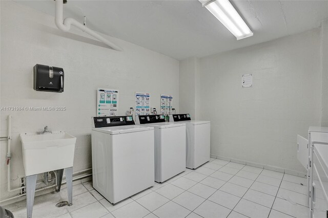 clothes washing area featuring washing machine and dryer and light tile patterned floors