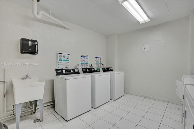 laundry area with light tile patterned flooring and washer and clothes dryer