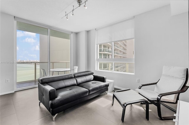 living room with a water view, track lighting, and a healthy amount of sunlight