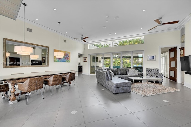 tiled living room with ceiling fan and a towering ceiling