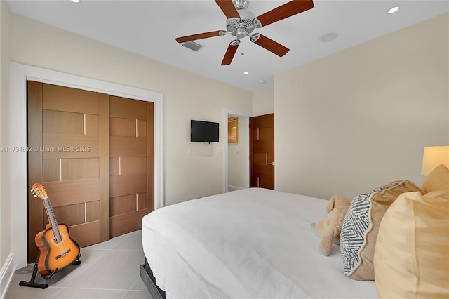 bedroom with light tile patterned floors, ceiling fan, and a closet