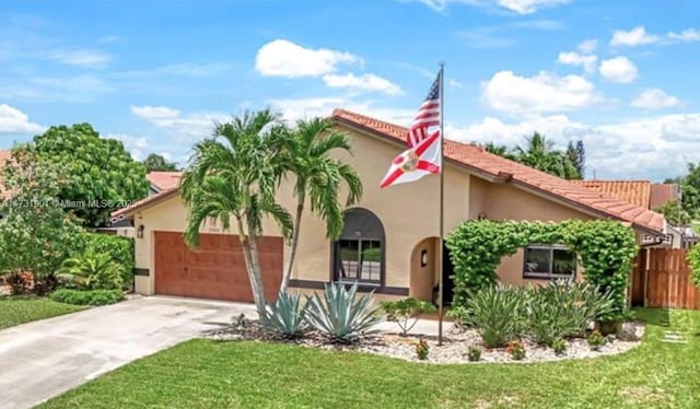 mediterranean / spanish house featuring a garage and a front yard