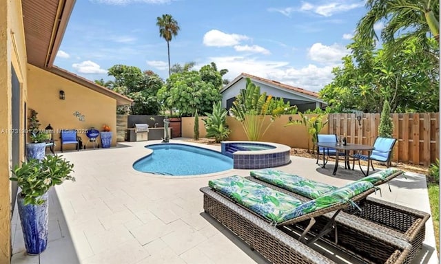 view of swimming pool with an in ground hot tub, exterior kitchen, and a patio area