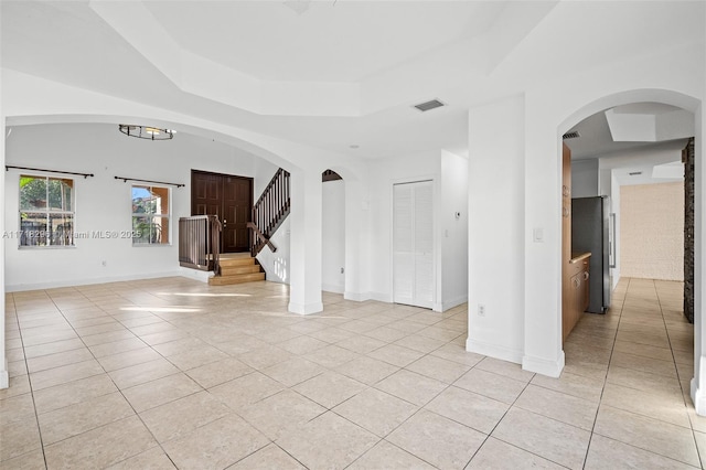 kitchen with sink, stainless steel appliances, a raised ceiling, and a kitchen island