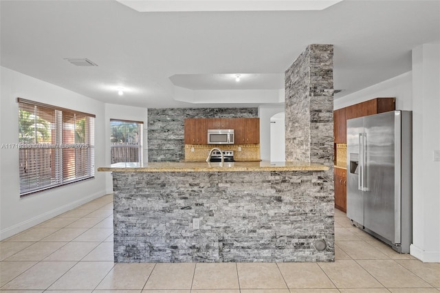 clothes washing area featuring washing machine and dryer, cabinets, and light tile patterned flooring