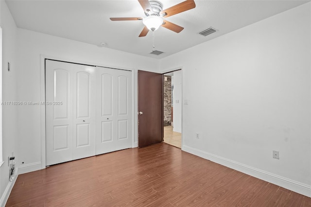 spare room with a healthy amount of sunlight, a tray ceiling, and light hardwood / wood-style floors