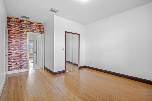 unfurnished bedroom with light wood-type flooring and a closet