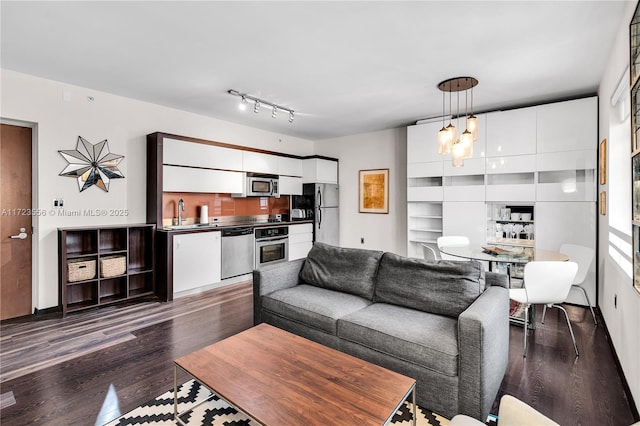 living room with an inviting chandelier and dark hardwood / wood-style flooring