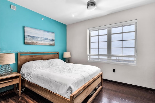 bedroom with dark hardwood / wood-style floors