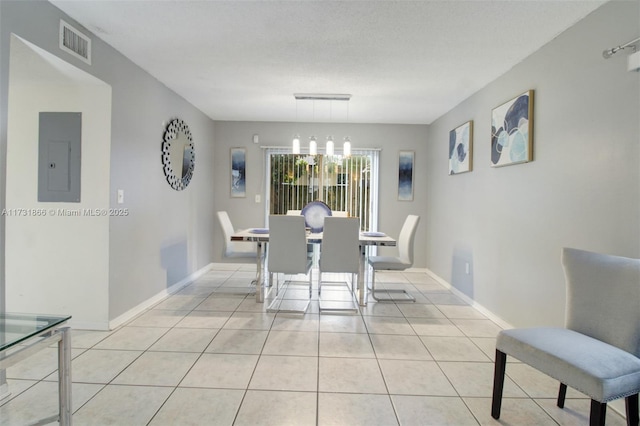 tiled dining space with a chandelier, electric panel, and a textured ceiling