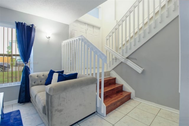 staircase featuring tile patterned flooring and a textured ceiling