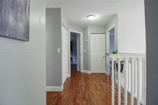 corridor with dark hardwood / wood-style flooring, radiator, and a textured ceiling