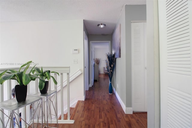 hallway featuring dark hardwood / wood-style floors and a textured ceiling