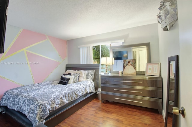 bedroom featuring dark wood-type flooring and a textured ceiling