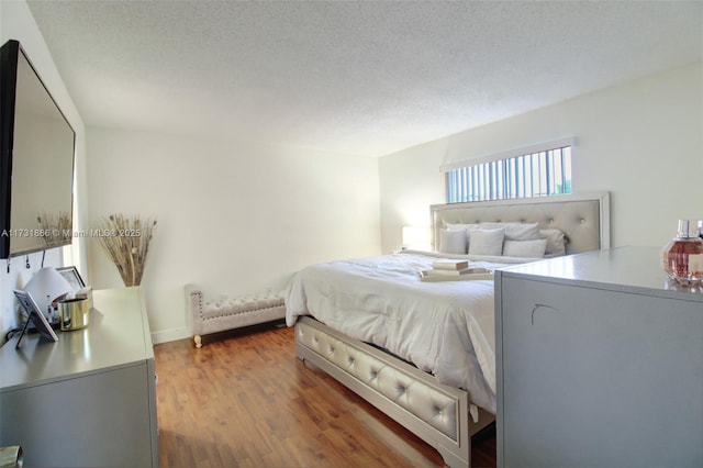 bedroom with hardwood / wood-style floors and a textured ceiling