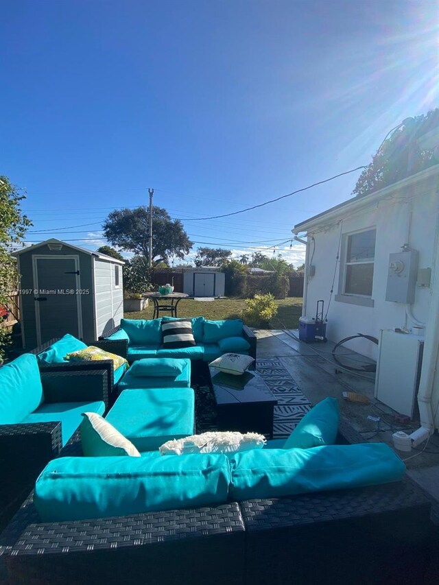 view of patio with an outdoor living space and a storage unit