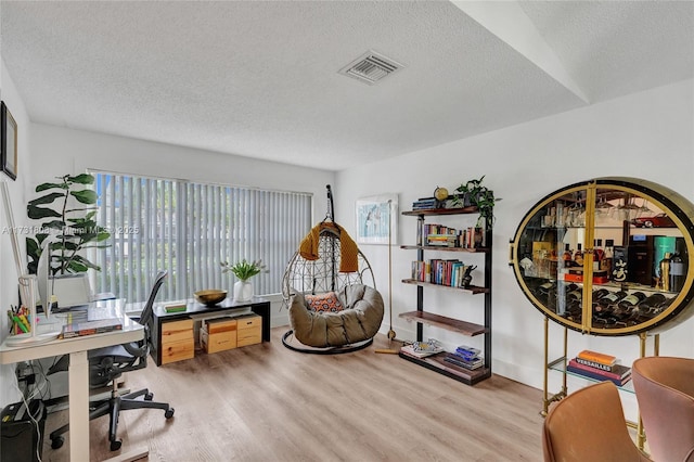 home office featuring a textured ceiling and light hardwood / wood-style floors