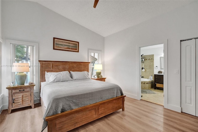 bedroom featuring connected bathroom, vaulted ceiling, hardwood / wood-style floors, and ceiling fan