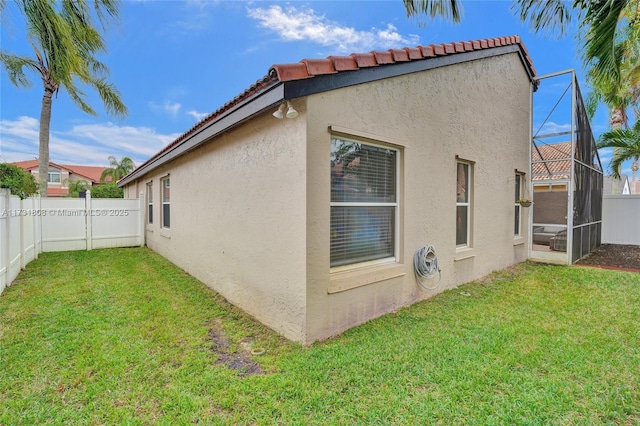 view of property exterior featuring a lanai and a lawn