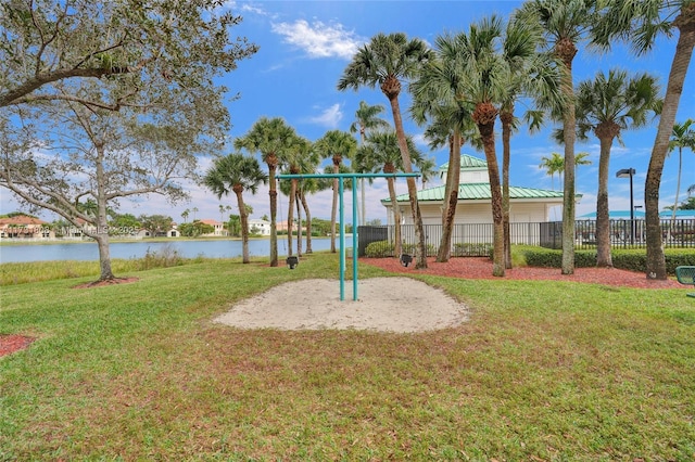 view of playground featuring a lawn and a water view