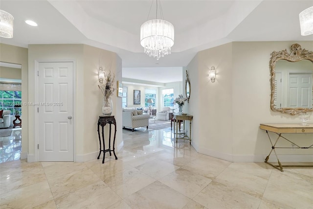 hallway featuring a chandelier and a tray ceiling