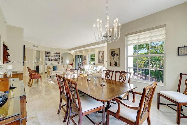 dining area featuring an inviting chandelier and built in features