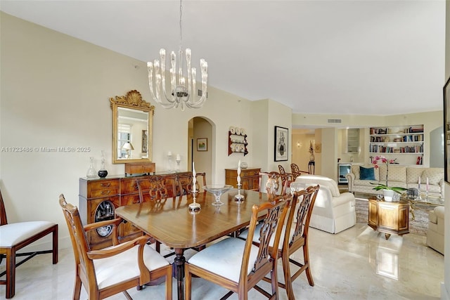 dining area featuring an inviting chandelier and built in shelves