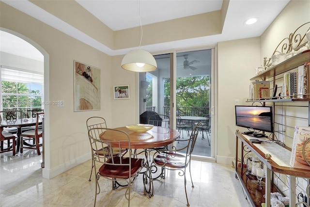 dining room with a raised ceiling and ceiling fan