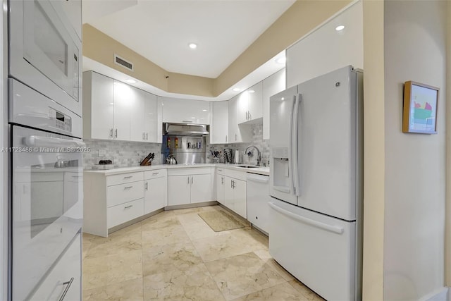 kitchen featuring sink, white cabinets, white appliances, and decorative backsplash