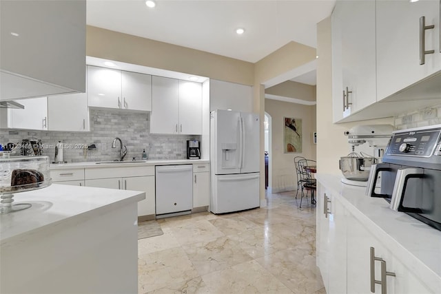 kitchen with tasteful backsplash, white cabinetry, sink, and white appliances