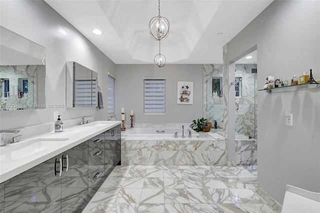 bathroom with an inviting chandelier, vanity, shower with separate bathtub, and a raised ceiling