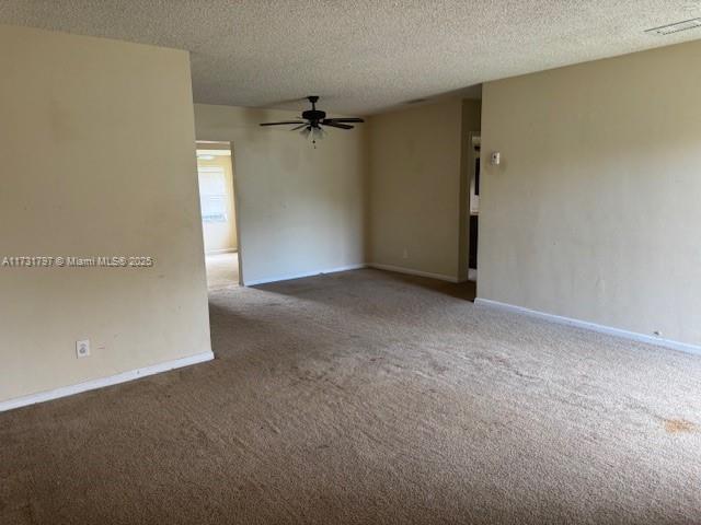 unfurnished room with ceiling fan, carpet, and a textured ceiling