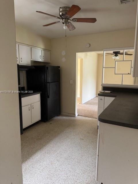 kitchen with black refrigerator, ceiling fan, and white cabinets