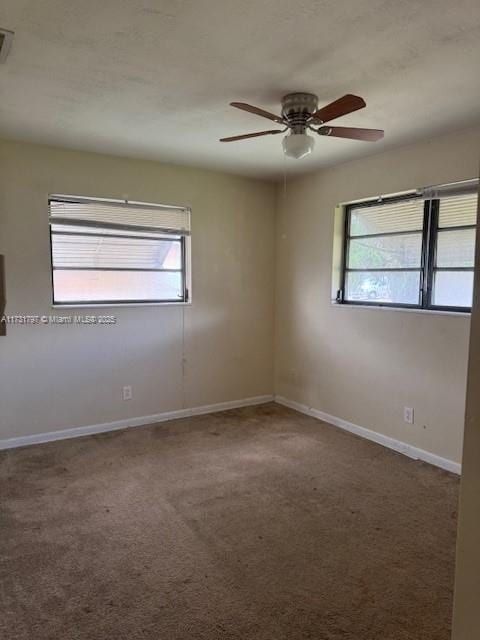 carpeted empty room featuring ceiling fan and a healthy amount of sunlight