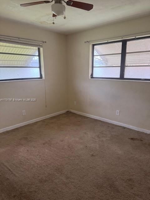 carpeted empty room featuring ceiling fan