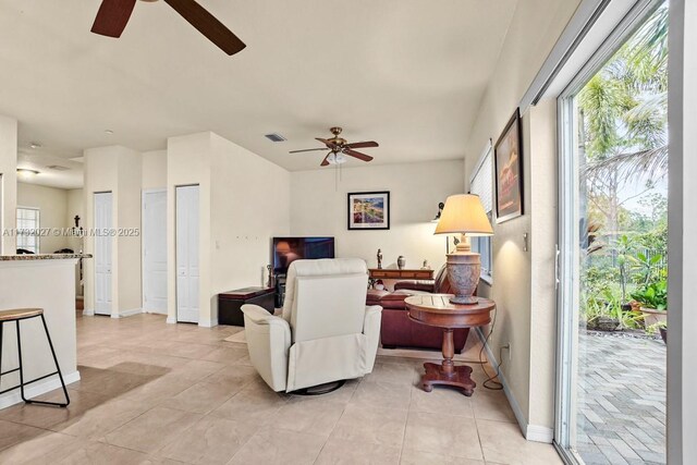 tiled living room with ceiling fan