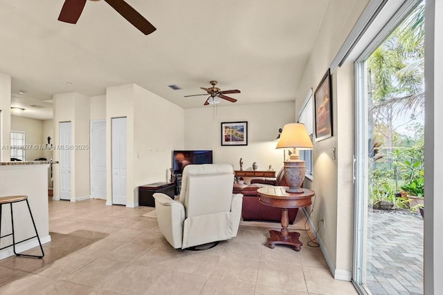 tiled living room featuring ceiling fan