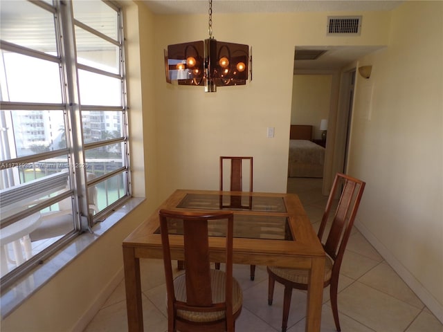 dining area featuring light tile patterned flooring, a notable chandelier, and a wealth of natural light